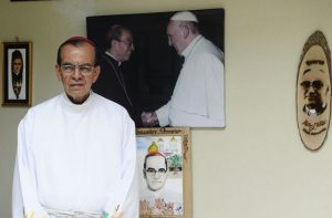 Kardinal Rosa Chavez vor einem Foto mit Papst Franziskus und drei Darstellungen von Oscar Romero