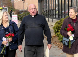 Father Stephen Imbarrato mit den beiden Helferinnen der Aktion „Rote Rosen“, die mit ihm verhaftet wurden.