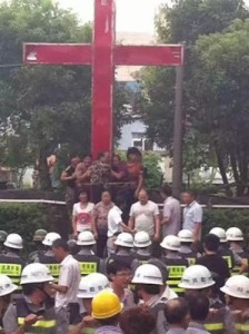 Christen verteidigen ein Kreuz gegen Polizei und Abbruchmannschaft