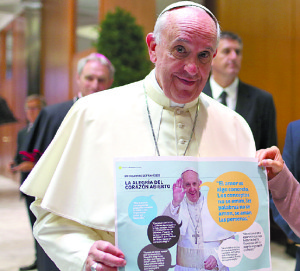 Papst Franziskus mit einem Exemplar der Kinderbuchreihe