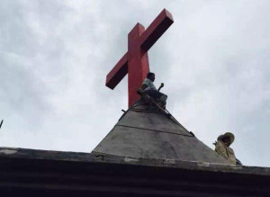 Christen halten das Dach ihrer Kirche besetzt, um die Zerstörung des Kreuzes zu verhindern